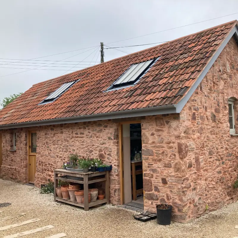Heritage barn renovation using reclaimed stone and lime mortar.