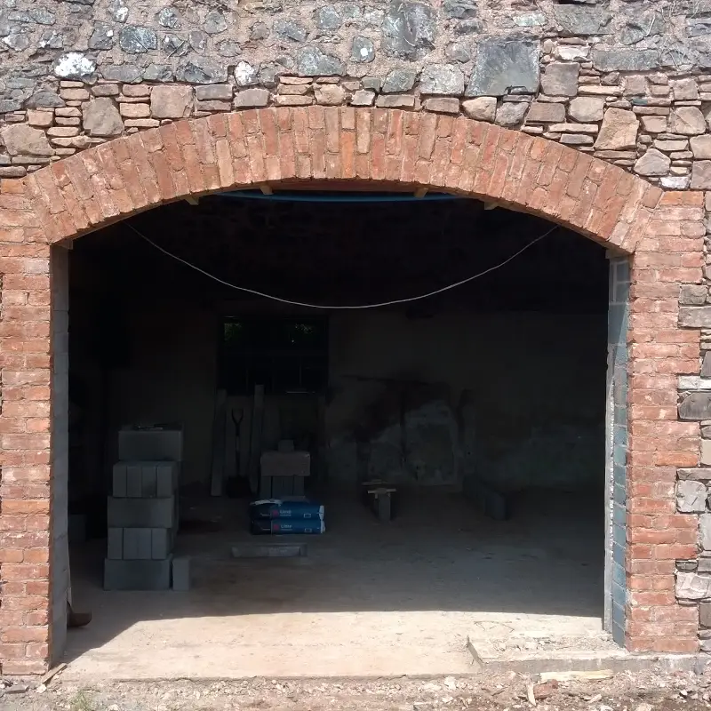 Repair of existing wall and construction of brick archway in a commercial barn renovation.